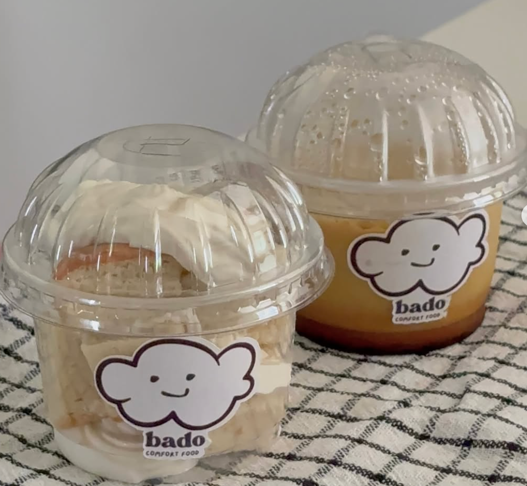 Bado chiffon cake cream cup and custard pudding cup side by side with dome lids and smiling cloud stickers