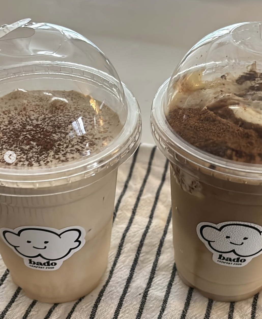 Two Bado espresso cold foam drinks side by side on a striped cloth